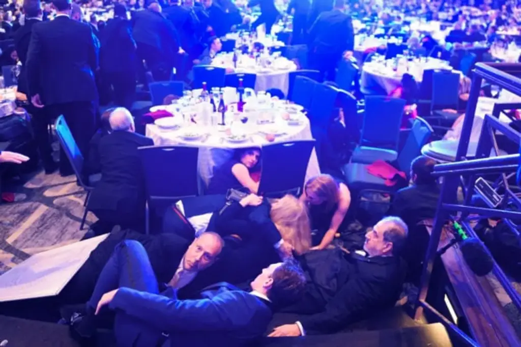 Kennedy, Boston Globe DC Bureau Chief Jackie Kucinich (redhead), and Shadow US Senator DC Paul Strauss hide under tables after an incident at the annual White House Correspondents Association Dinner April 25, 2026 in Washington, DC. According to reports, President Donald Trump, along with other government officials, was evacuated from the Washington Hilton after what sounded like gunfire. (Photo by Nathan Howard/Getty Images)