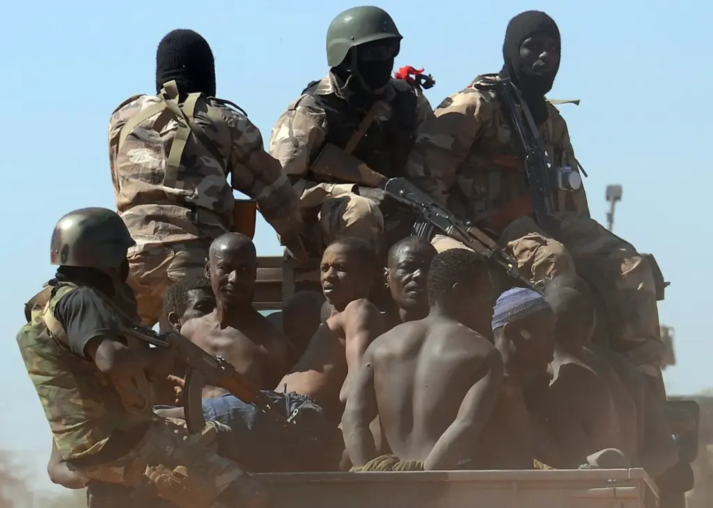 Malian soldiers transport in a pickup truck a dozen suspected Islamist rebels on February 8, 2013 after arresting them north of Gao. (Photo by PASCAL GUYOT/AFP via Getty Images)