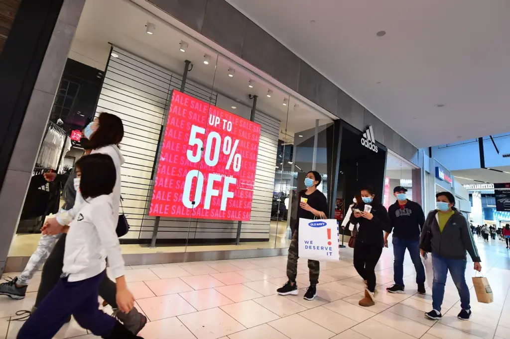 People walk stores offering sales at a shopping mall in Santa Anita, California on December 20, 2021. (Photo by FREDERIC J. BROWN/AFP via Getty Images)